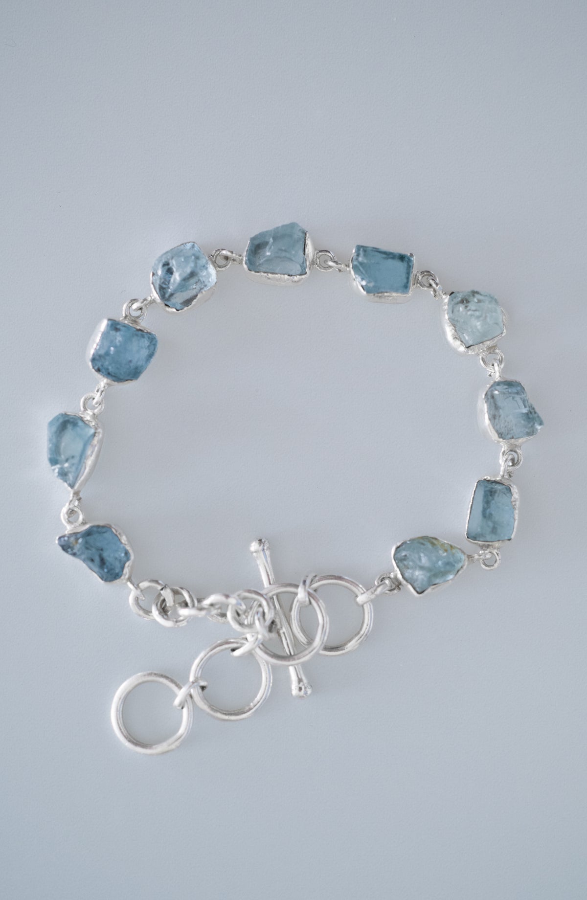 Rustic Stone Bracelet in aquamarine, laid flat with the toggle clasp at the bottom